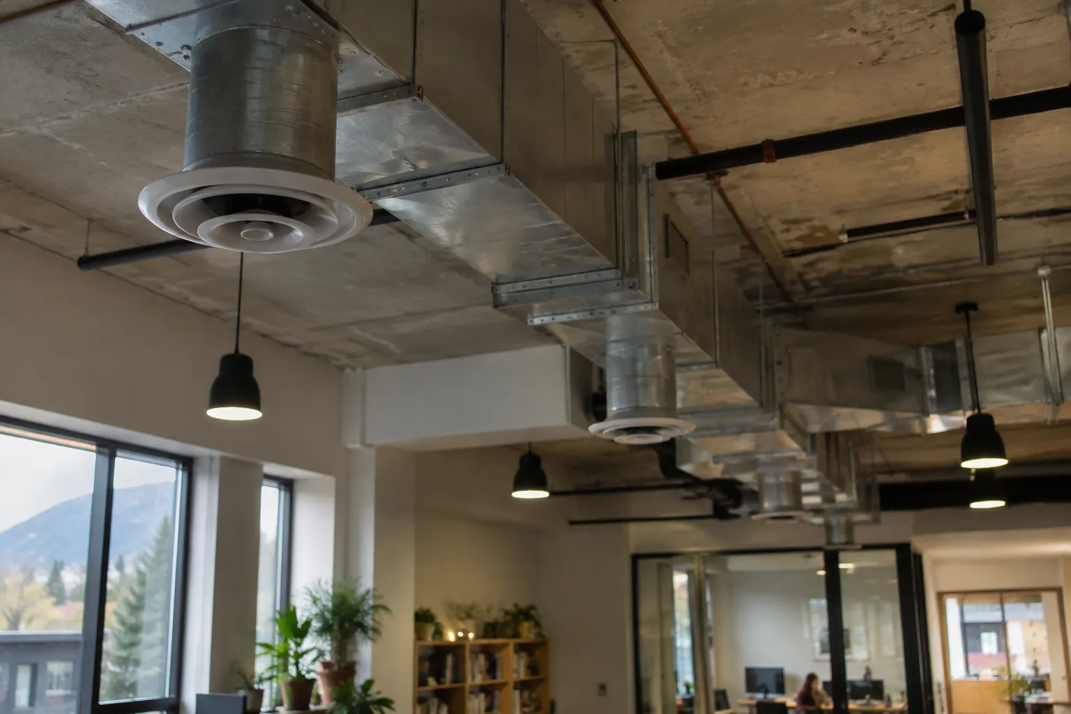 Exposed ventilation ductwork running along the ceiling of a commercial building
